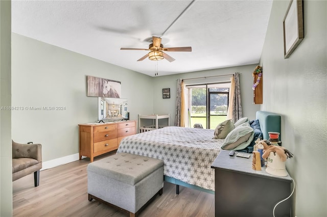 bedroom featuring ceiling fan, light hardwood / wood-style floors, a textured ceiling, and access to outside