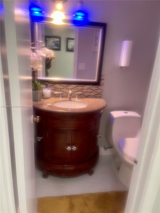 half bathroom featuring toilet, tasteful backsplash, and vanity