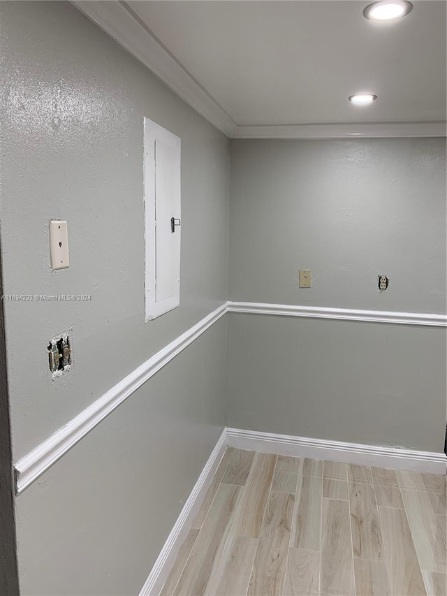 basement featuring electric panel and light hardwood / wood-style flooring