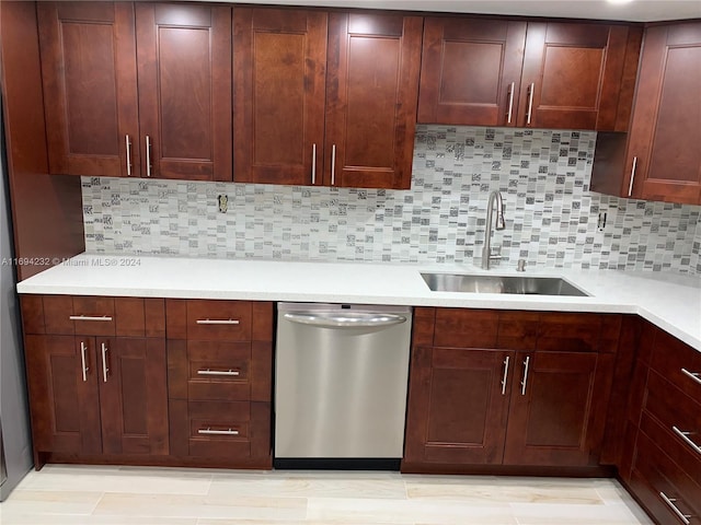 kitchen with tasteful backsplash, stainless steel dishwasher, and sink