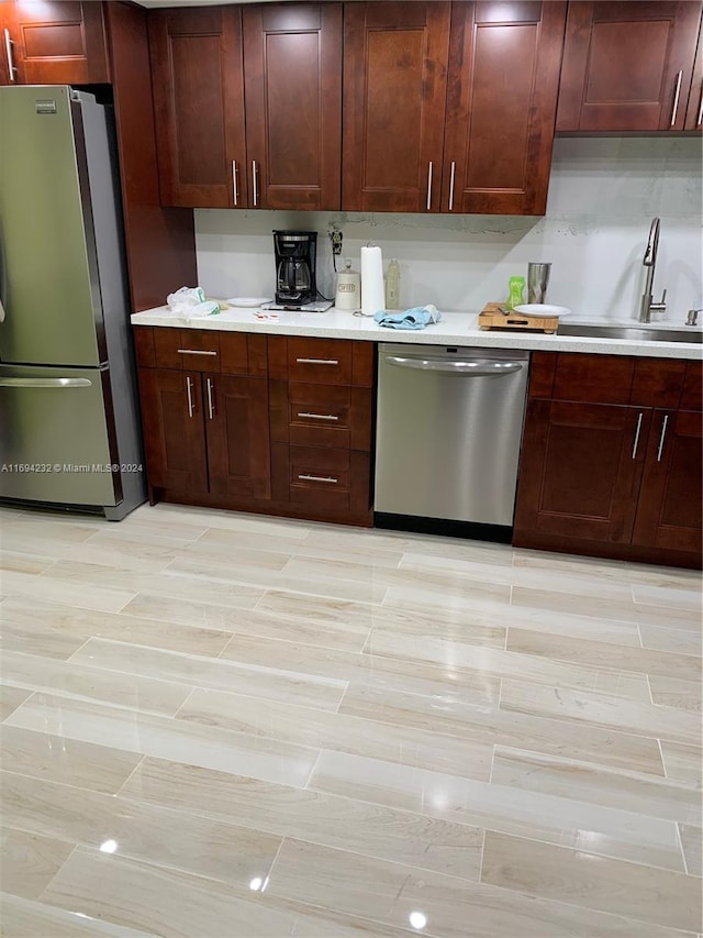 kitchen featuring stainless steel appliances, light hardwood / wood-style flooring, and sink