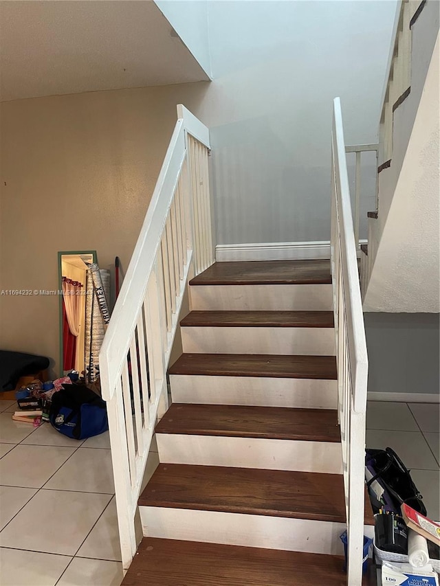 staircase featuring tile patterned floors