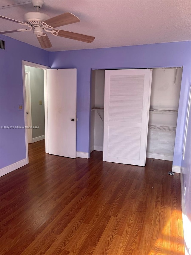 unfurnished bedroom with ceiling fan, dark hardwood / wood-style flooring, and a closet