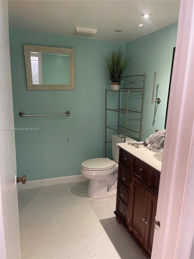 bathroom featuring tile patterned floors, vanity, and toilet