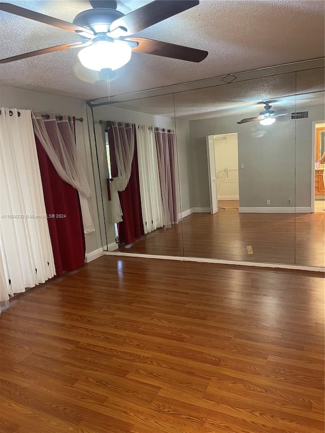 unfurnished room with hardwood / wood-style floors, ceiling fan, and a textured ceiling