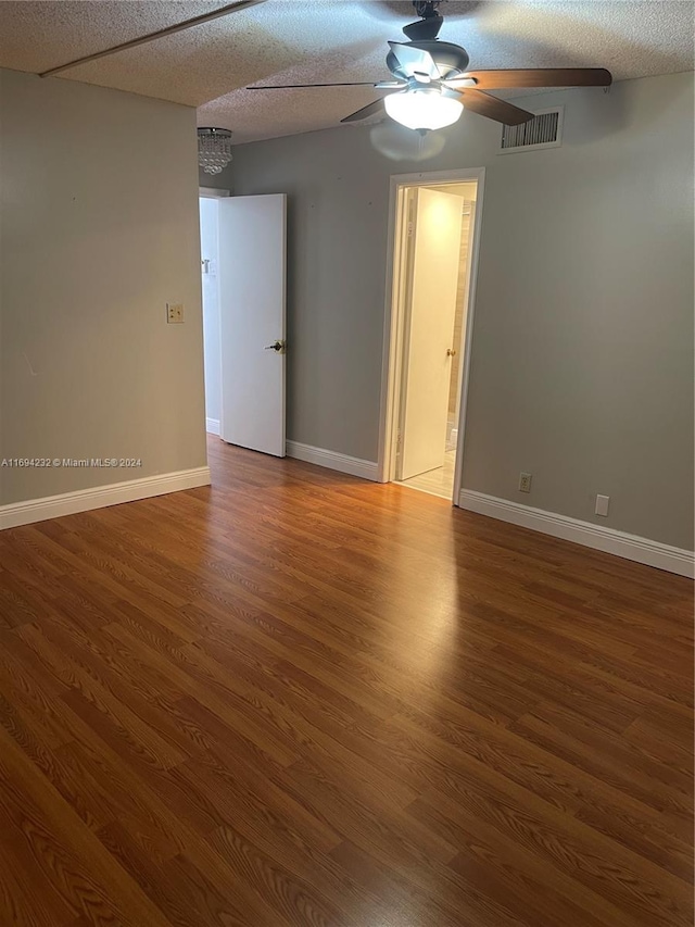 spare room featuring hardwood / wood-style flooring, ceiling fan, and a textured ceiling