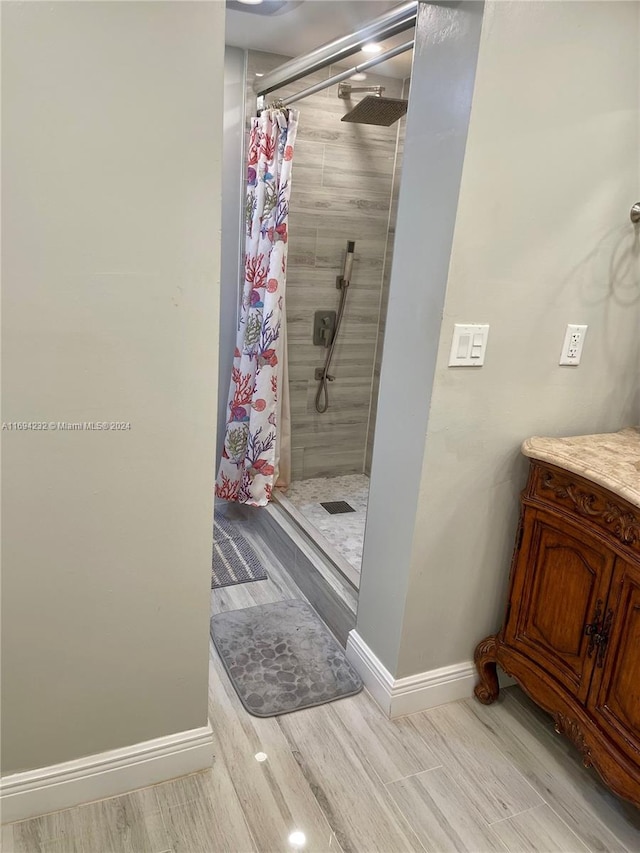 bathroom featuring a shower with curtain, vanity, and wood-type flooring