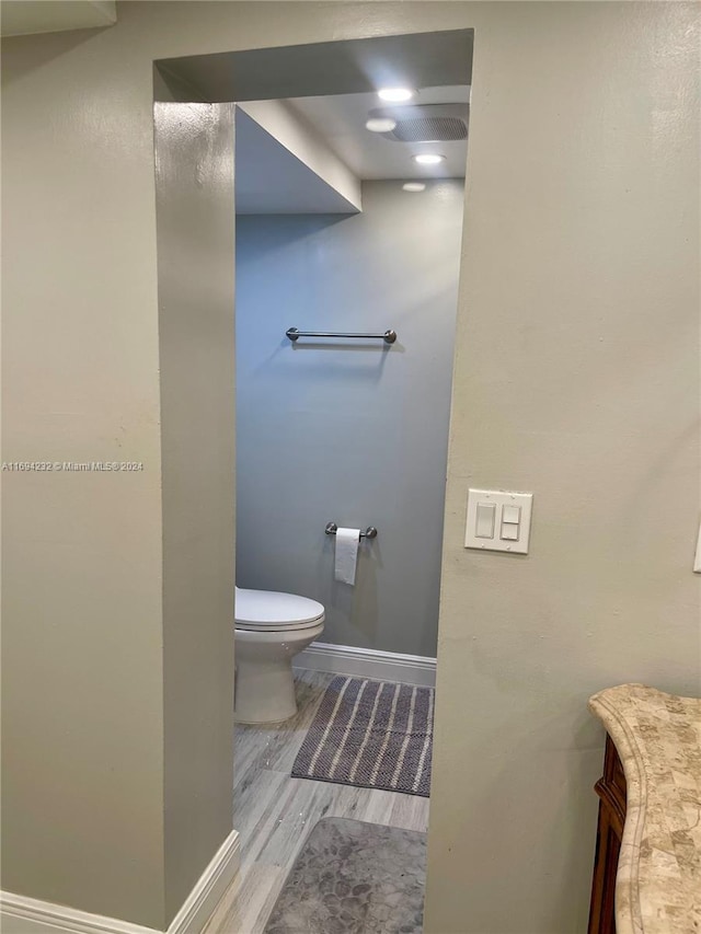 bathroom with wood-type flooring and toilet