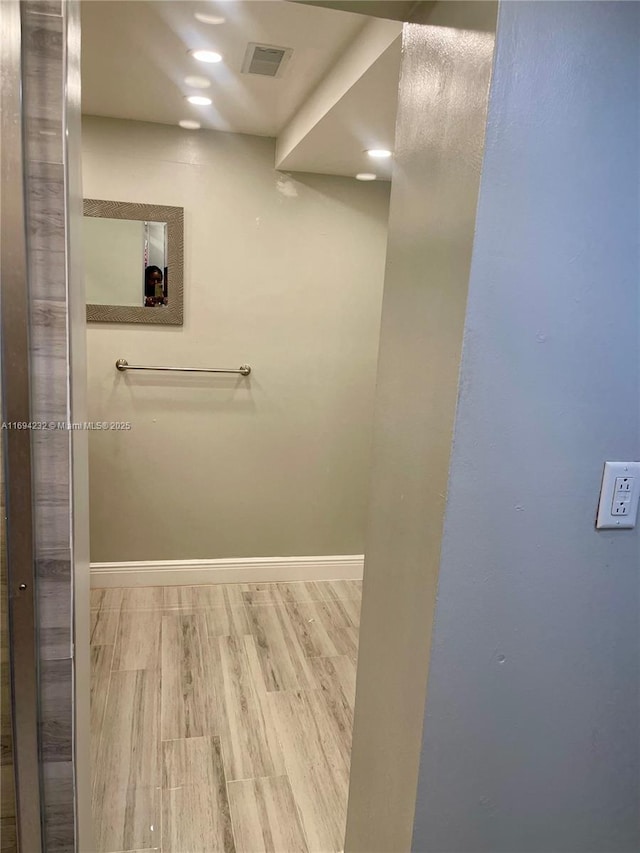 bathroom with baseboards, visible vents, and wood finished floors