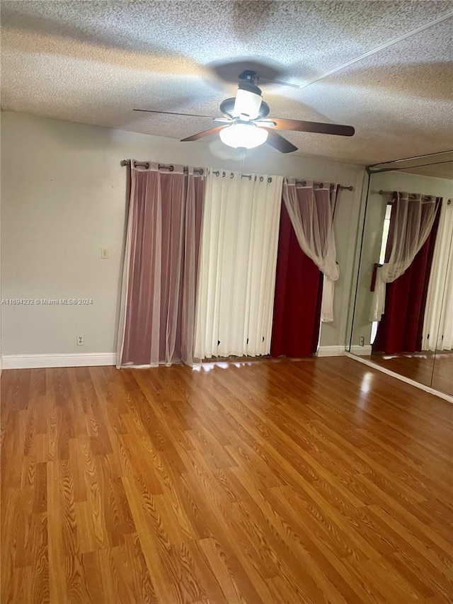 unfurnished room with hardwood / wood-style floors, a textured ceiling, and ceiling fan