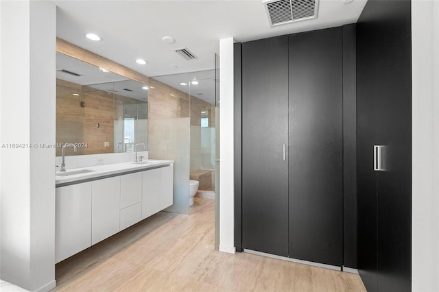 bathroom featuring vanity, wood-type flooring, an enclosed shower, and toilet