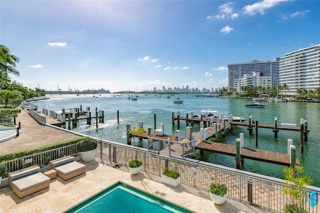 dock area with a fenced in pool, a patio area, and a water view