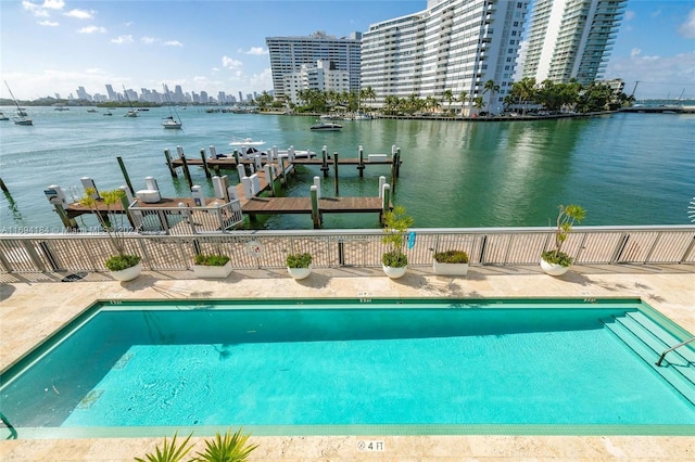 view of swimming pool with a water view and a boat dock