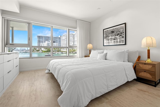 tiled bedroom with multiple windows and a water view