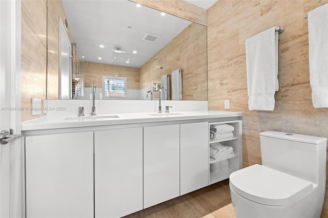 bathroom featuring vanity, wood-type flooring, tile walls, and toilet