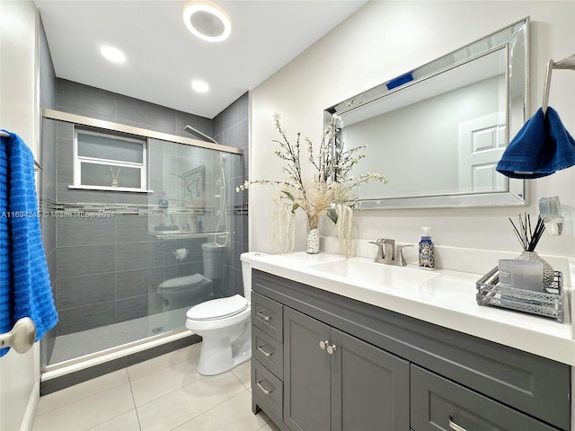 bathroom featuring tile patterned flooring, vanity, toilet, and a shower with shower door