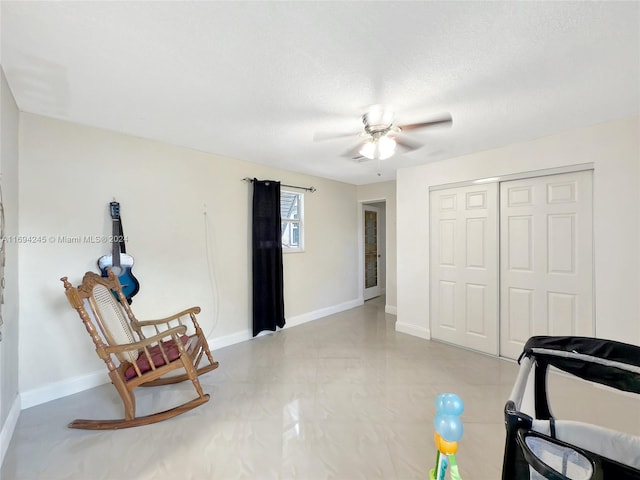 living area featuring a textured ceiling and ceiling fan