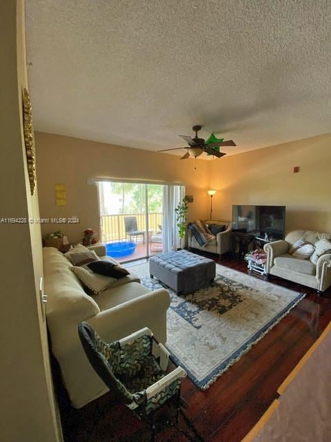 living room featuring ceiling fan, hardwood / wood-style floors, and a textured ceiling