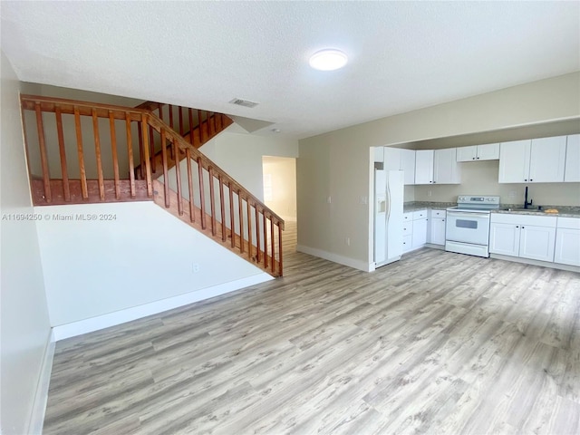 kitchen with white cabinetry, sink, light hardwood / wood-style floors, a textured ceiling, and white appliances