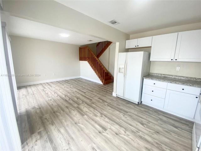 kitchen featuring white refrigerator with ice dispenser, white cabinets, and light hardwood / wood-style floors