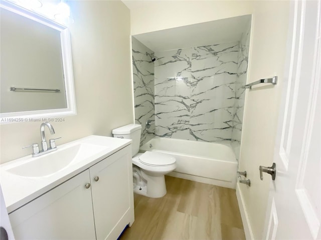 full bathroom featuring hardwood / wood-style floors, vanity, tiled shower / bath combo, and toilet