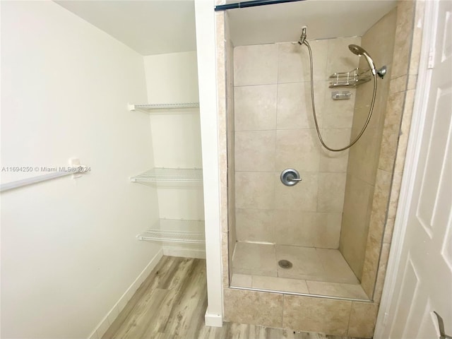 bathroom featuring a tile shower and hardwood / wood-style flooring