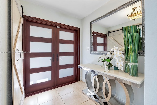 tiled entryway featuring a barn door and french doors