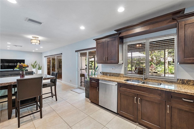 kitchen featuring dishwasher, light stone counters, plenty of natural light, and sink