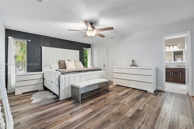 bedroom featuring hardwood / wood-style floors, ceiling fan, and connected bathroom