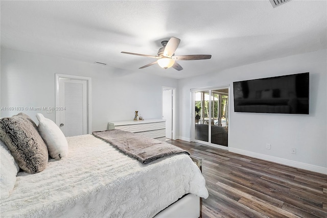 bedroom featuring a textured ceiling, access to outside, ceiling fan, dark wood-type flooring, and a closet