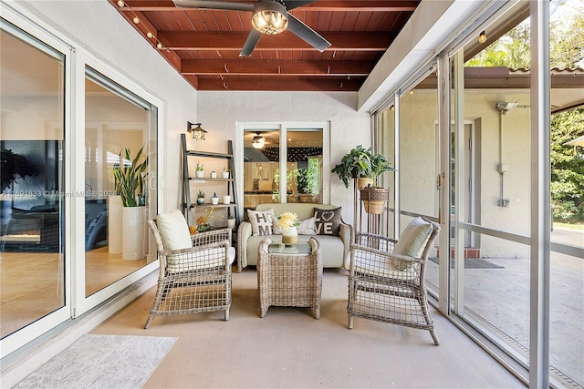 sunroom with beamed ceiling, ceiling fan, plenty of natural light, and wood ceiling