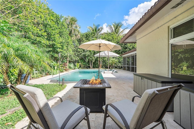 view of swimming pool with a patio area and a fire pit