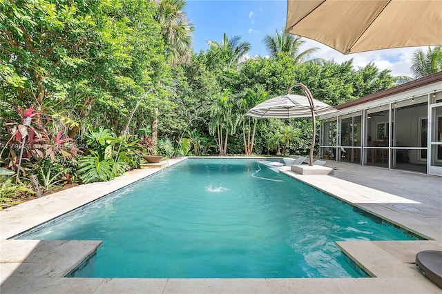 view of pool featuring a patio area, a sunroom, and pool water feature