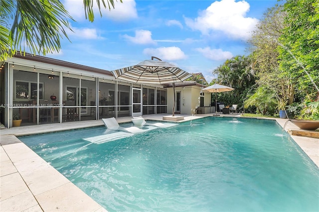 view of pool with a sunroom, pool water feature, and a patio