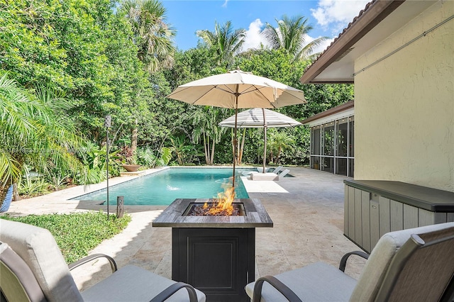 view of pool featuring an outdoor fire pit and a patio