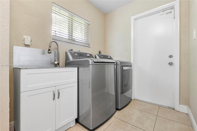 laundry room featuring cabinets, separate washer and dryer, and light tile patterned floors