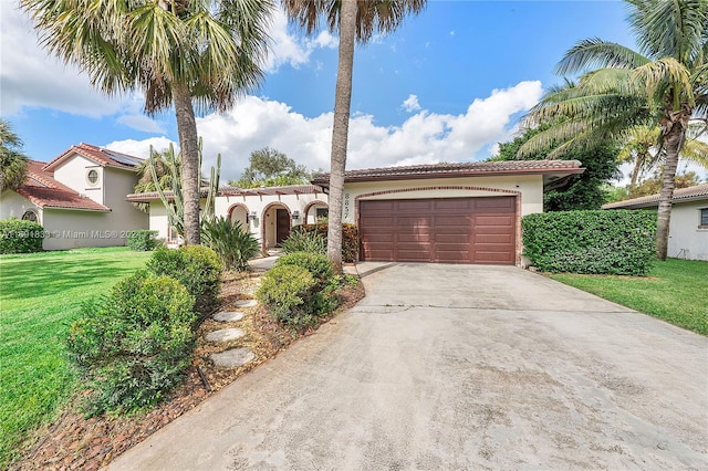 mediterranean / spanish house featuring a garage and a front lawn