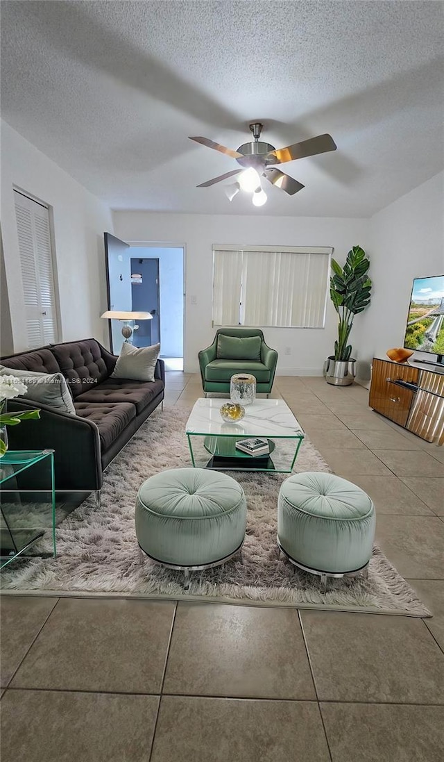 tiled living room with a textured ceiling and ceiling fan