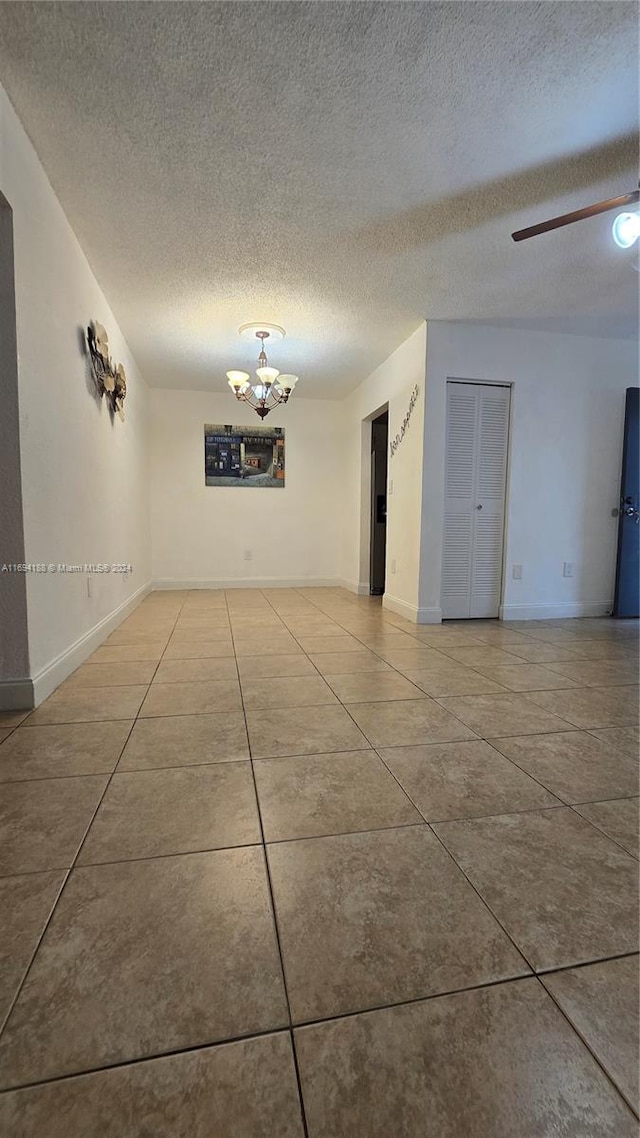 unfurnished room with tile patterned flooring and a textured ceiling