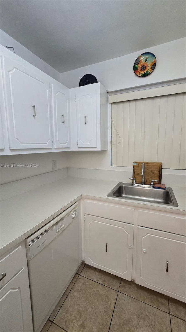 kitchen with dishwasher, light tile patterned flooring, white cabinetry, and sink