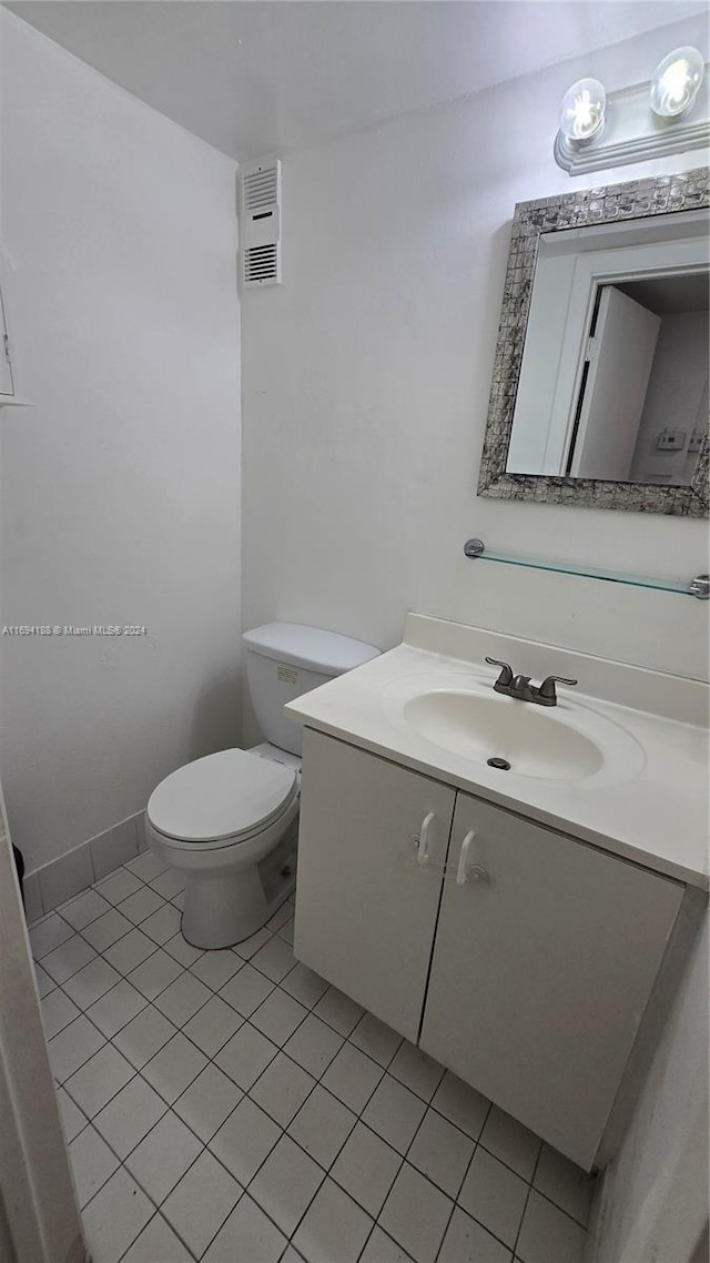 bathroom featuring tile patterned flooring, vanity, and toilet