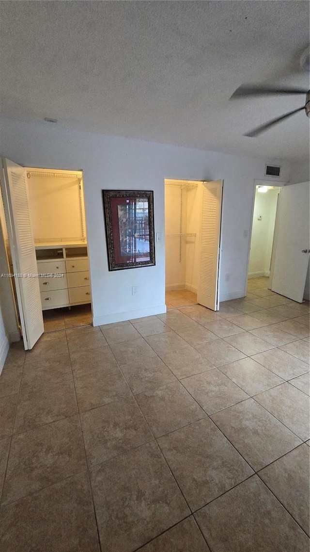 unfurnished bedroom with ceiling fan and a textured ceiling