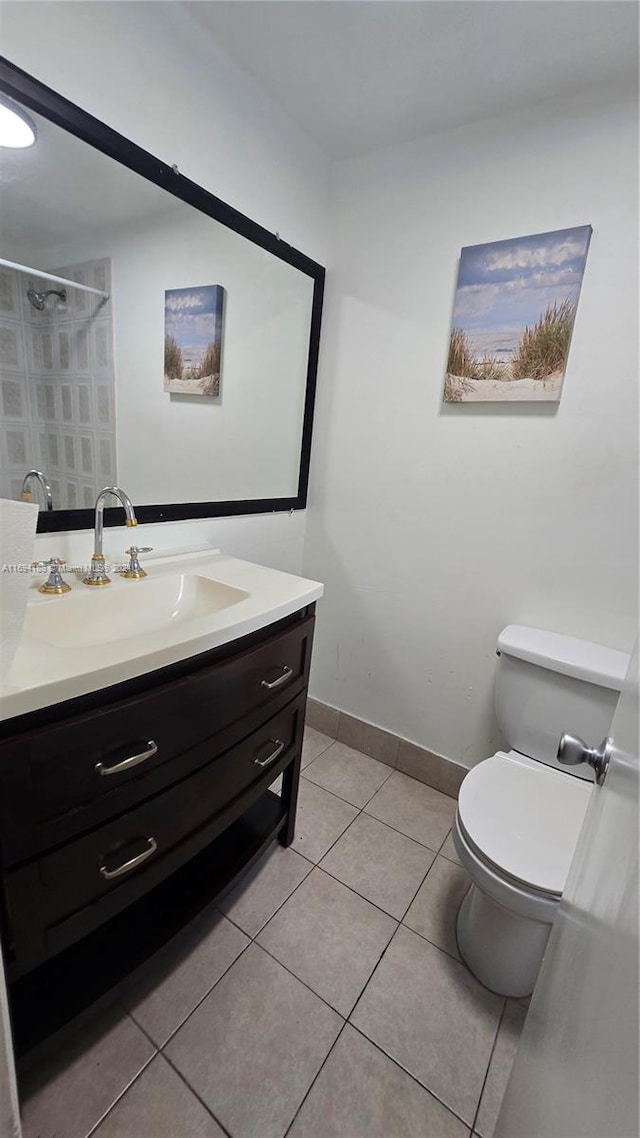 bathroom with tile patterned flooring, vanity, and toilet