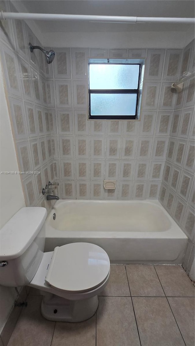 bathroom with tile patterned flooring, tiled shower / bath combo, and toilet