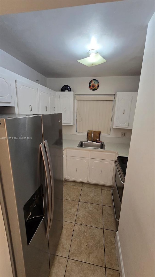 kitchen featuring white cabinets, light tile patterned flooring, sink, and appliances with stainless steel finishes