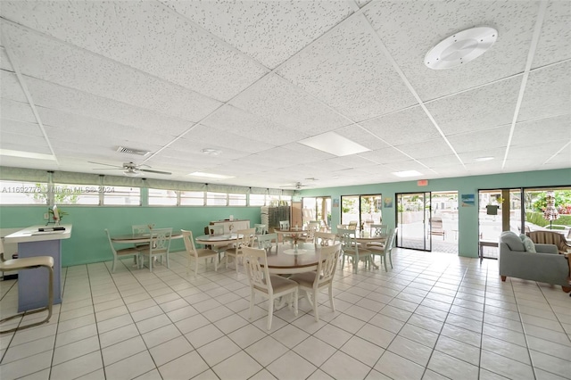 unfurnished dining area with a paneled ceiling, ceiling fan, and light tile patterned floors