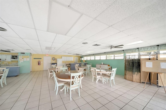 tiled dining room featuring a paneled ceiling and ceiling fan