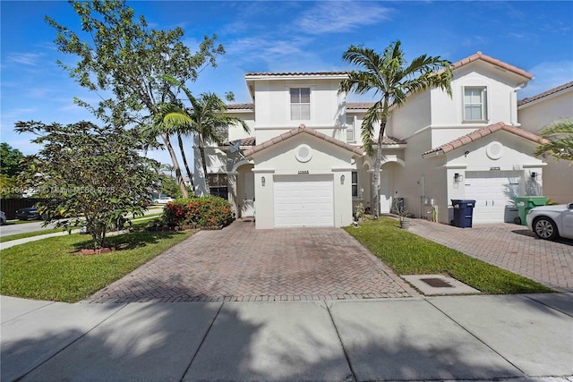 mediterranean / spanish home with a front lawn and a garage