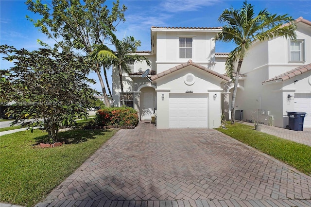 mediterranean / spanish-style home featuring a garage and a front lawn