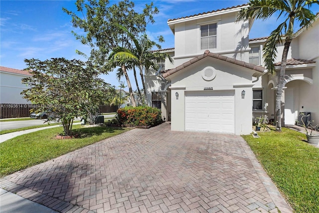 mediterranean / spanish-style home featuring a garage and a front yard